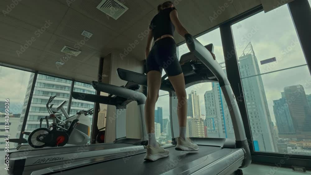 Young woman doing exercises in gym with city view Young woman doing exercises in gym with city view