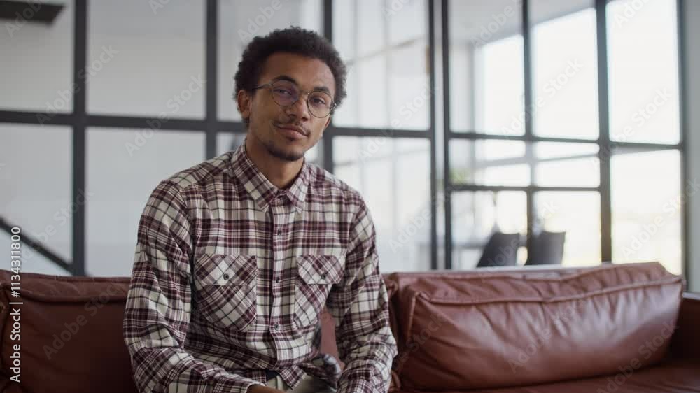 Confident Young Man Sitting with Arms Crossed Looking at Camera Confident Young Man Sitting with Arms Crossed Looking at Camera