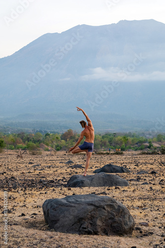 Man Practicing Yoga Meditation Outdoors in Nature with Mountain View.