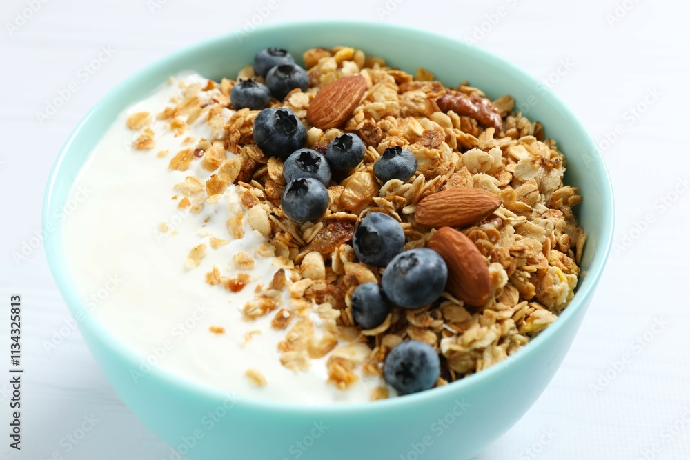 Delicious granola with berries and yogurt on a light background Delicious granola with berries and yogurt on a light background