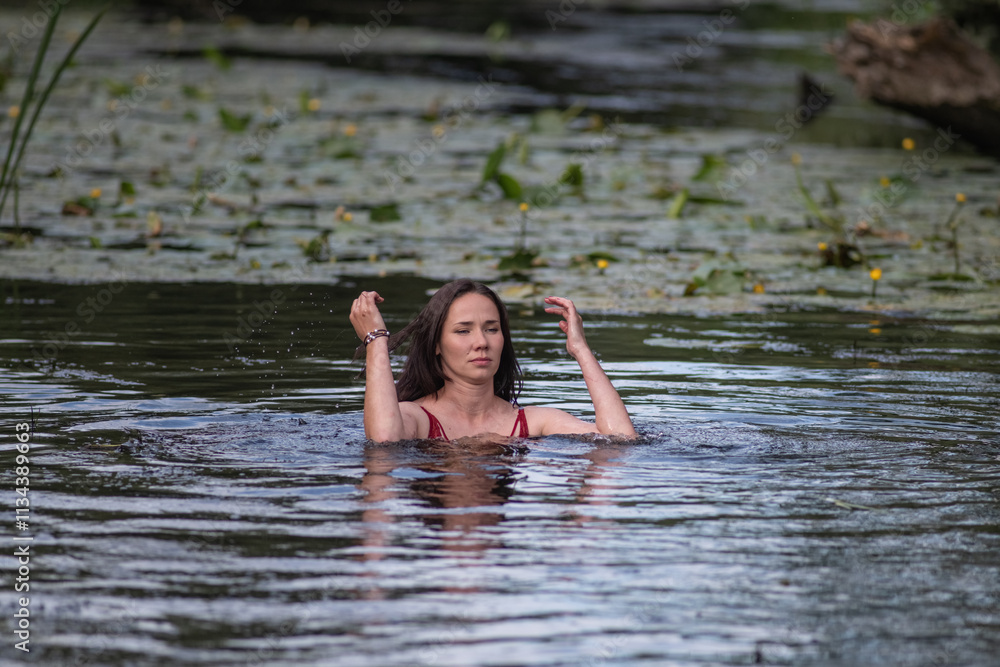 A beautiful young girl is swimming in the water. A beautiful young girl is swimming in the water.