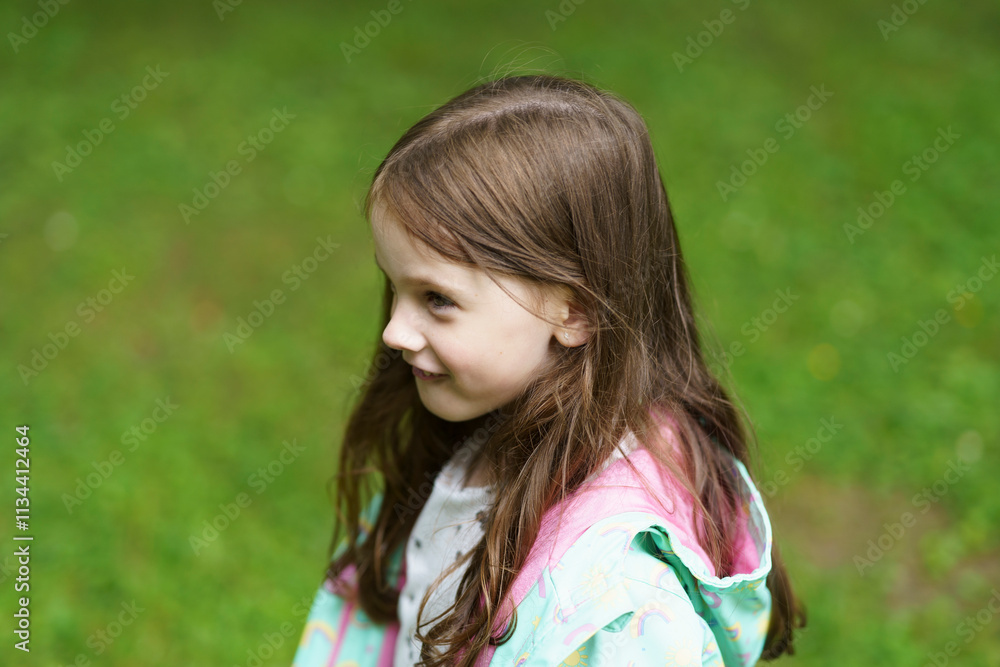Lonely sad girl on the playground in a raincoat. Concept of difficult childhood and psychological problems Lonely sad girl on the playground in a raincoat. Concept of difficult childhood and psychological problems