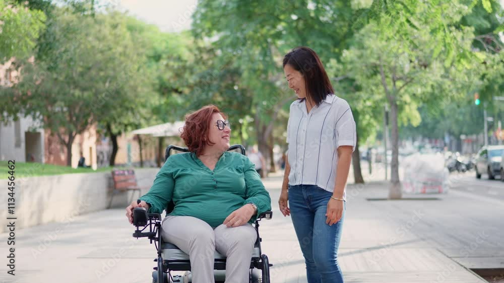 Woman walking with her friend in a wheelchair Woman walking with her friend in a wheelchair
