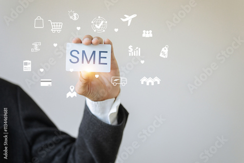 A person is holding a card with the letters SME on it. The card is surrounded by various icons and symbols