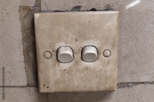 White Clipsal light switches mounted on a tiled wall