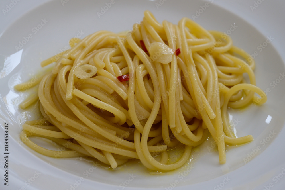 Spaghetti Colatura di Alici with Garlic and Peperoncini on a White Plate Spaghetti Colatura di Alici with Garlic and Peperoncini on a White Plate