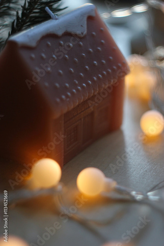 Christmas house candle. Christmas candle in garland lights. House shaped candle. Candle home decor