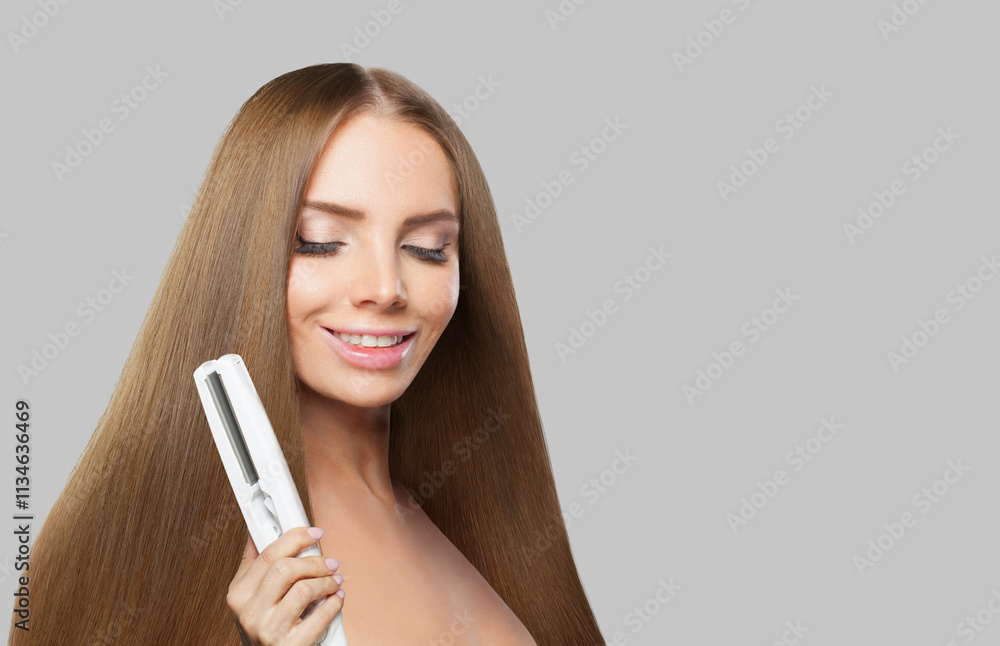 Glad brunette woman holding straight hair iron and straightening her long smooth shiny hair on white background. Haircare, hairstyle, hairdressing and hair styling concept Glad brunette woman holding straight hair iron and straightening her long smooth shiny hair on white background. Haircare, hairstyle, hairdressing and hair styling concept