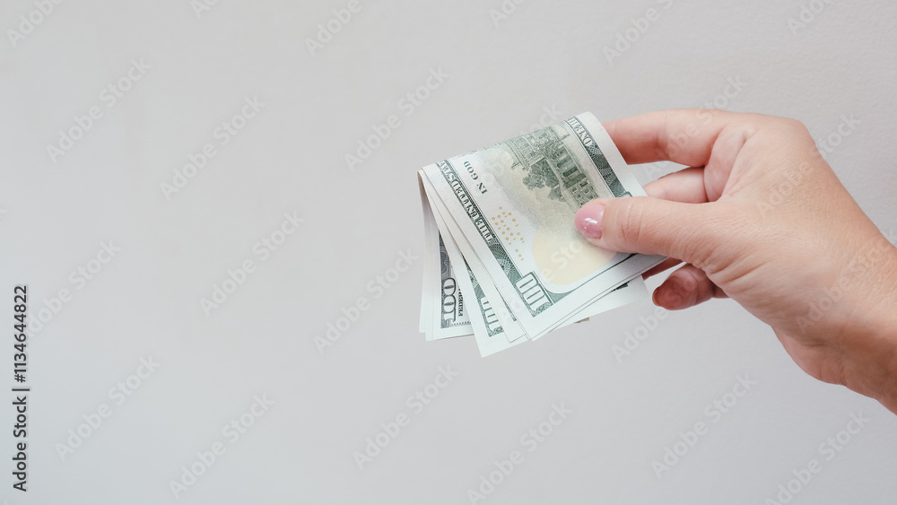 Woman's hand holding dollars on white background Woman's hand holding dollars on white background