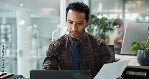 Photos Business, man and documents with laptop in office for data entry in CRM system and online sales report