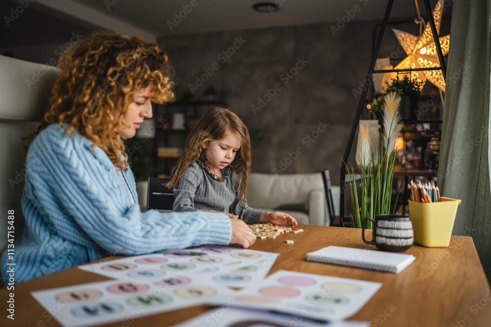 Fototapeta premium little girl and speech therapist practice together at home