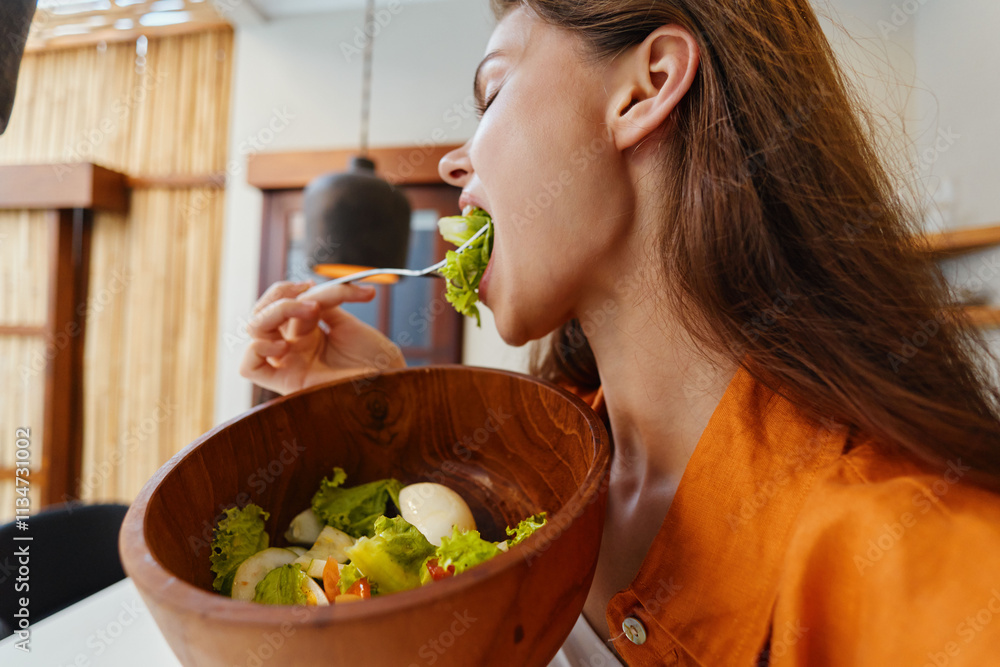 Young woman enjoying a fresh salad in a modern kitchen, highlighting healthy eating habits with vibrant colors and natural elements for a seasonal lifestyle Young woman enjoying a fresh salad in a modern kitchen, highlighting healthy eating habits with vibrant colors and natural elements for a seasonal lifestyle
