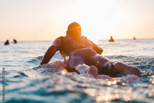 Photography Surfer paddling to join the lineup, Watergate Bay, Newquay, Cornwall, UK