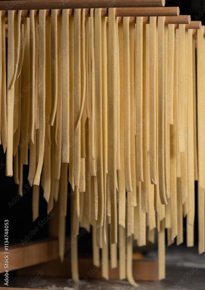 Fresh fettuccini noodles drying on a pasta rack Fresh fettuccini noodles drying on a pasta rack