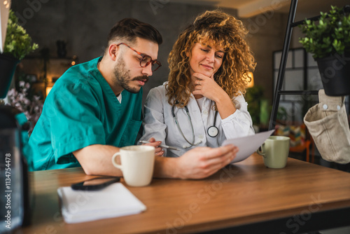 two doctors colleagues man and woman review patient files together