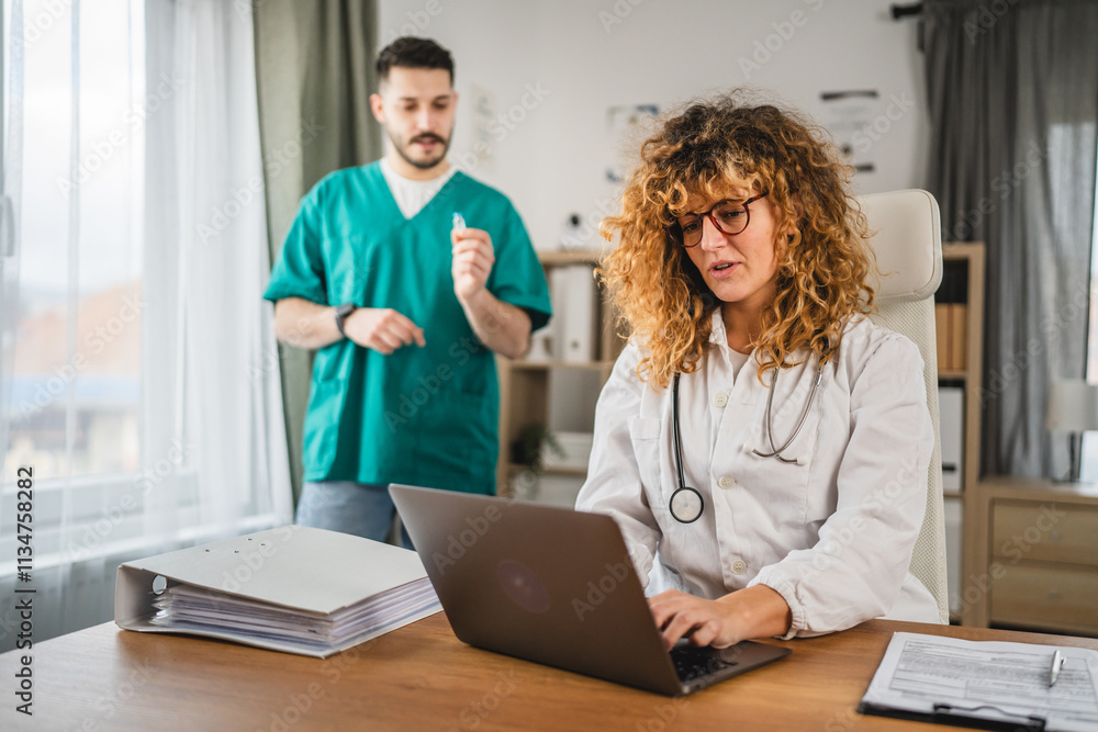 woman doctor in lab coat sit in her medical office and work on laptop woman doctor in lab coat sit in her medical office and work on laptop