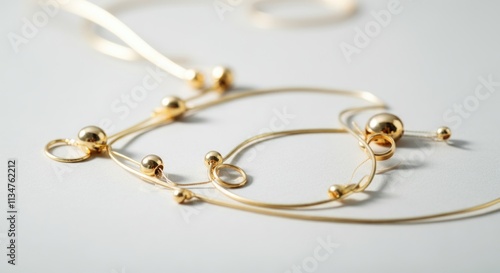 Elegant gold necklace with loops and beads on smooth surface