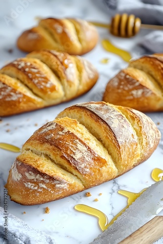 Freshly baked bread loaves on a marble surface with honey drizzles.