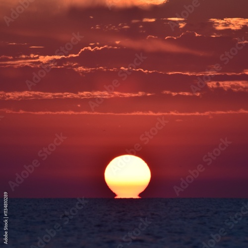 sun setting into ocean