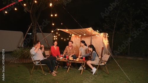 Family together celebrate anniversary in garden. Senior give gift to granddaughter. Outdoor camping activity to relax with relatives, spend time with multigeneration cross generation gap. Divergence. photo