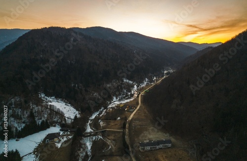 Golden hues of sunset cast a warm glow over the snow-dusted valleys of Piatra Craiului, revealing the tranquil beauty of Rasnov and Plaiul Foii in Brasov photo