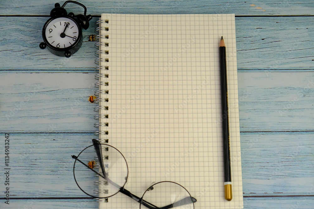 flat lay of a blank note book for text space. Educational concept with text space on yellow background. surrounded by yellow tools such as pen, alarm clock and calculator flat lay of a blank note book for text space. Educational concept with text space on yellow background. surrounded by yellow tools such as pen, alarm clock and calculator