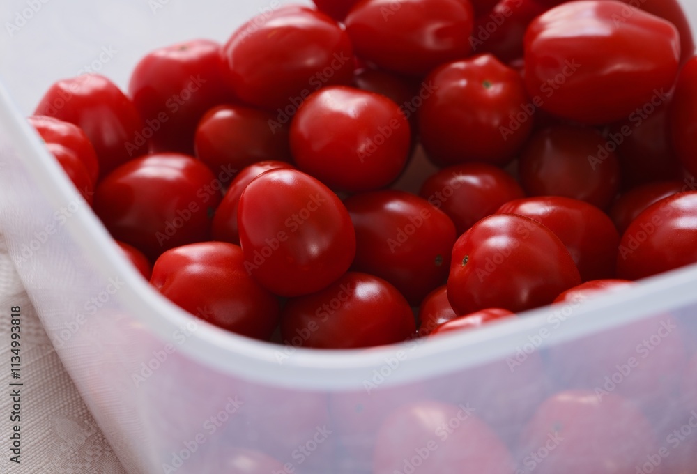 Red cherry tomatoes in a plastic container. Close-up. Red cherry tomatoes in a plastic container. Close-up.