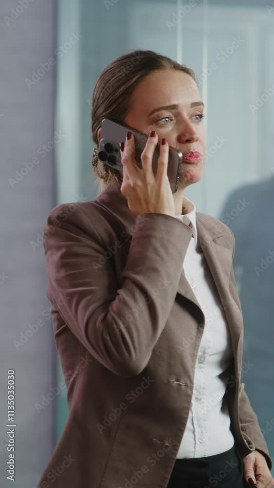Vertical shot successful businesswoman talks on mobile phone about business deal, discusses new project or company strategy with partner. Female marketing specialist works in equipped E-commerce Vertical shot successful businesswoman talks on mobile phone about business deal, discusses new project or company strategy with partner. Female marketing specialist works in equipped E-commerce