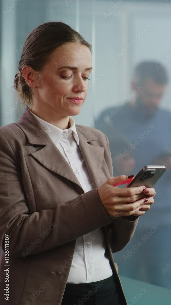 Vertical shot successful businesswoman chats with business partner in messenger app or consults client on mobile phone. Female financial specialist works in modern, equipped office of E-commerce Vertical shot successful businesswoman chats with business partner in messenger app or consults client on mobile phone. Female financial specialist works in modern, equipped office of E-commerce