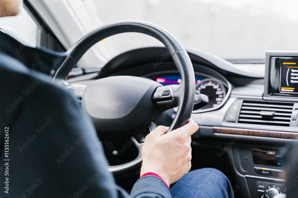 A person is driving a car with focused attention, concentrating on the road ahead of them A person is driving a car with focused attention, concentrating on the road ahead of them