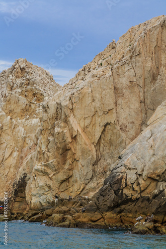 A rocky cliff with a blue sky in the background