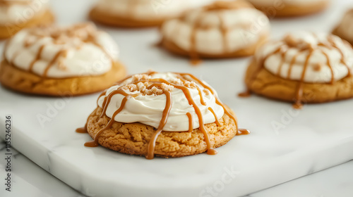 Delicious pumpkin cookies with creamy frosting and caramel drizzle on a white marble surface. Drizzle. Illustration photo