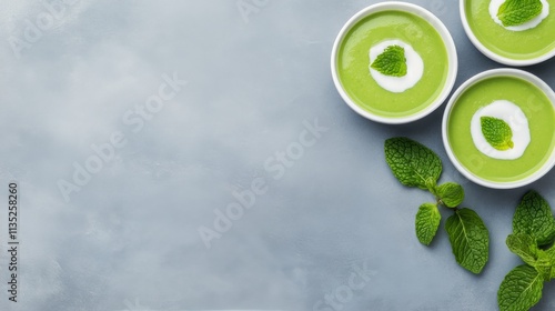 Refreshing green herbal tea served in bowls with fresh mint leaves on a light...