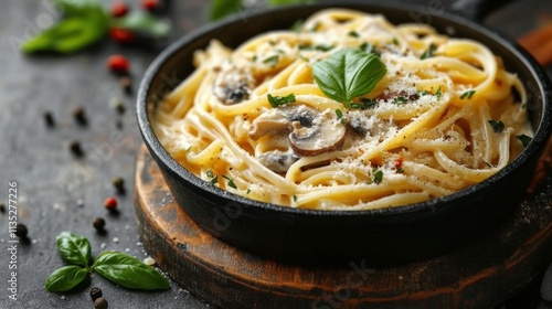 Creamy mushroom pasta served in a skillet with fresh basil on a rustic backgr...