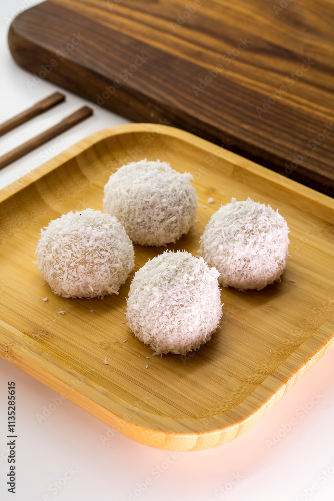 Japanese dessert mochi with red bean filling and coconut flakes. chopsticks. food concept. Japanese dessert mochi with red bean filling and coconut flakes. chopsticks. food concept.