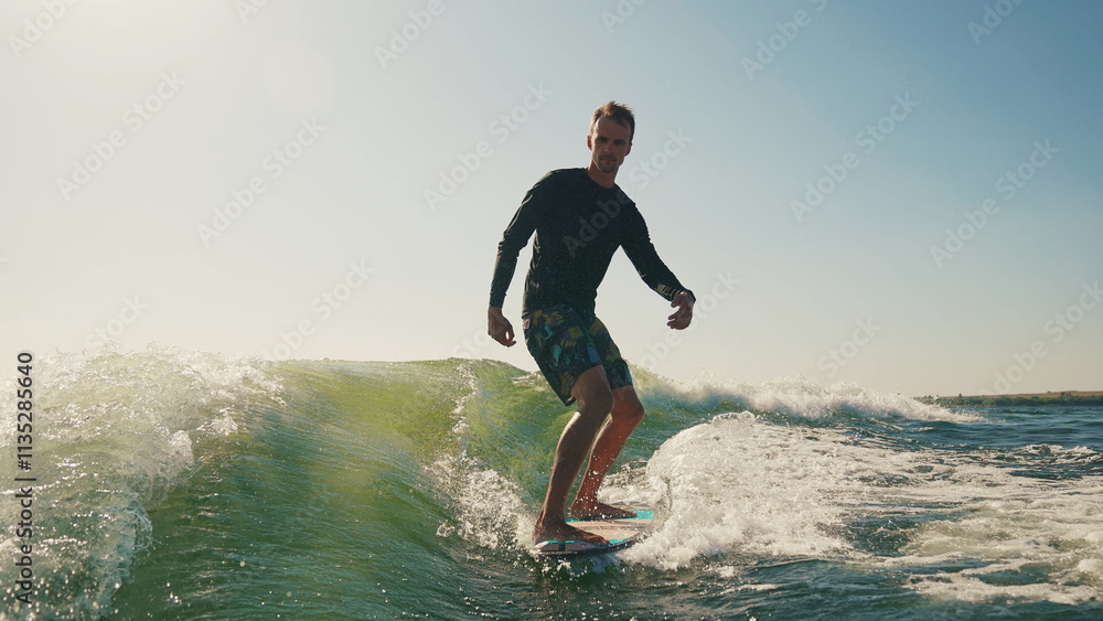 A wakeboarder performs exciting tricks on his board, moving quickly through the water. The footage shows smooth turns, jumps and acrobatics, highlighting the athlete's skill and endurance. Ideal for t A wakeboarder performs exciting tricks on his board, moving quickly through the water. The footage shows smooth turns, jumps and acrobatics, highlighting the athlete's skill and endurance. Ideal for t