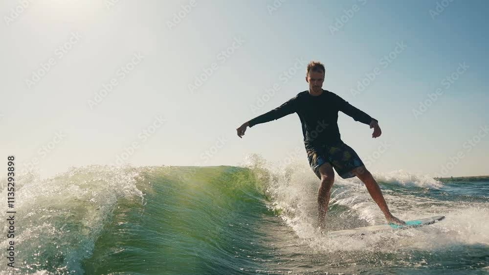 A wakeboarder performs exciting tricks on his board, moving quickly through the water. The footage shows smooth turns, jumps and acrobatics, highlighting the athlete's skill and endurance. Ideal for t A wakeboarder performs exciting tricks on his board, moving quickly through the water. The footage shows smooth turns, jumps and acrobatics, highlighting the athlete's skill and endurance. Ideal for t