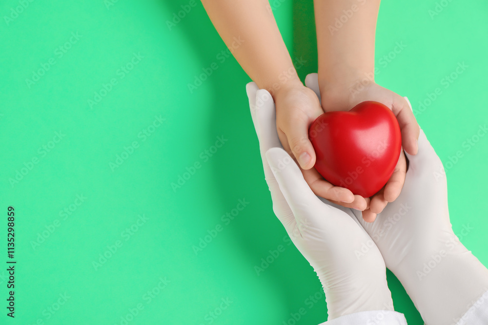 Doctor and child holding heart model on light green background, top view. Space for text Doctor and child holding heart model on light green background, top view. Space for text