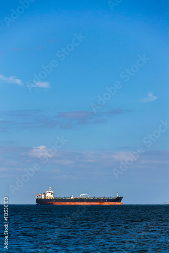 Oil tanker ship on sea with copy space on heaven and water, sunny day photo