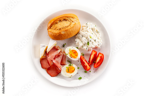 Continental breakfast - boiled eggs, white cheese, ham, tomatoes and bread roll on white background photo