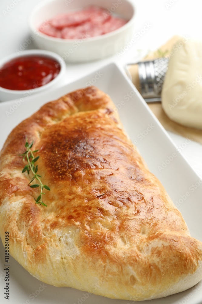 Delicious fresh calzone pizza on white wooden table, closeup Delicious fresh calzone pizza on white wooden table, closeup