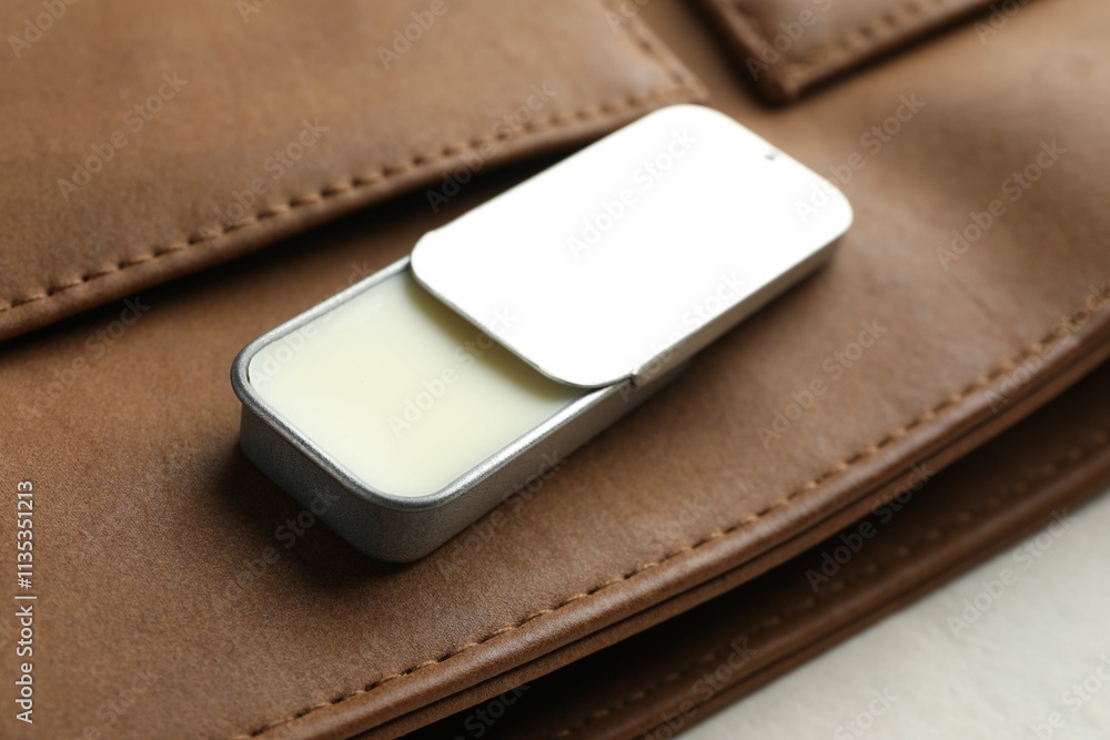Natural solid perfume in container and leather bag on light table, closeup Natural solid perfume in container and leather bag on light table, closeup