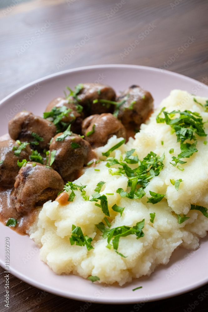 Swedish Meatballs with Gravy Sauce on a plate with mashed potatoes on a wooden background Swedish Meatballs with Gravy Sauce on a plate with mashed potatoes on a wooden background