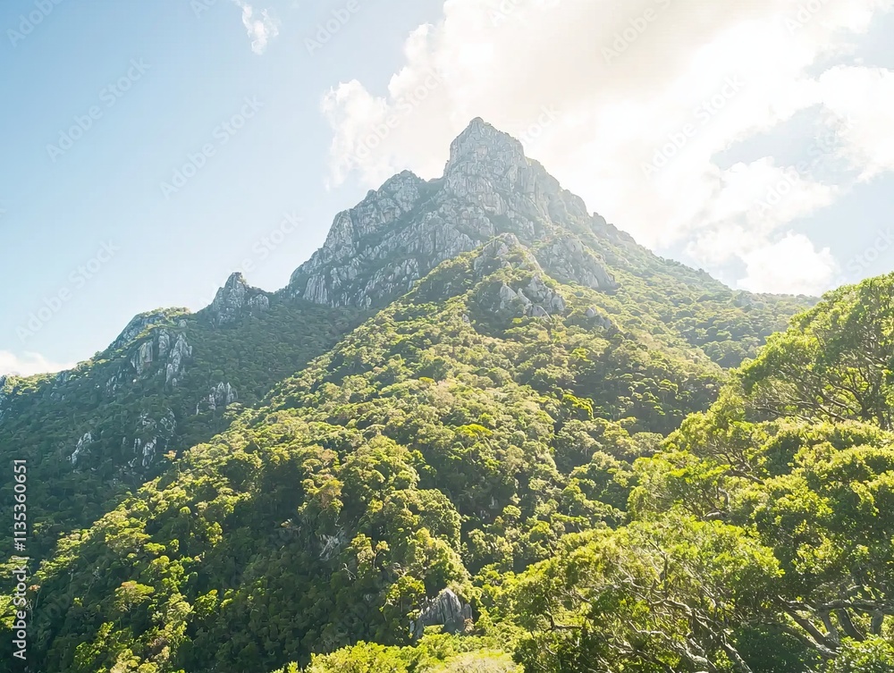 Fototapeta premium Scenic mountain landscape with lush greenery and bright sky.