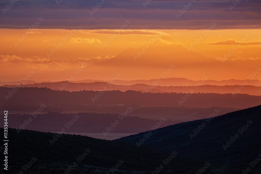 Sunset Hilly Landscape, volcano in the distant background Sunset Hilly Landscape, volcano in the distant background