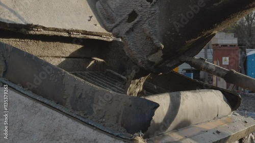Pouring concrete, construction. Cement from the cement mixer is poured into Concrete pump. Close up 
