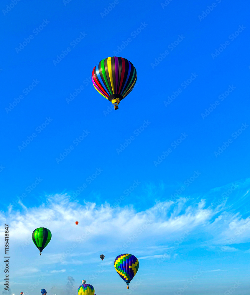 Fototapeta premium Hot Air Balloons Floating in the Blue Sky with a Few Clouds