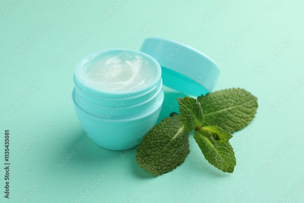 Natural lip balm and mint leaves on turquoise background, closeup Natural lip balm and mint leaves on turquoise background, closeup