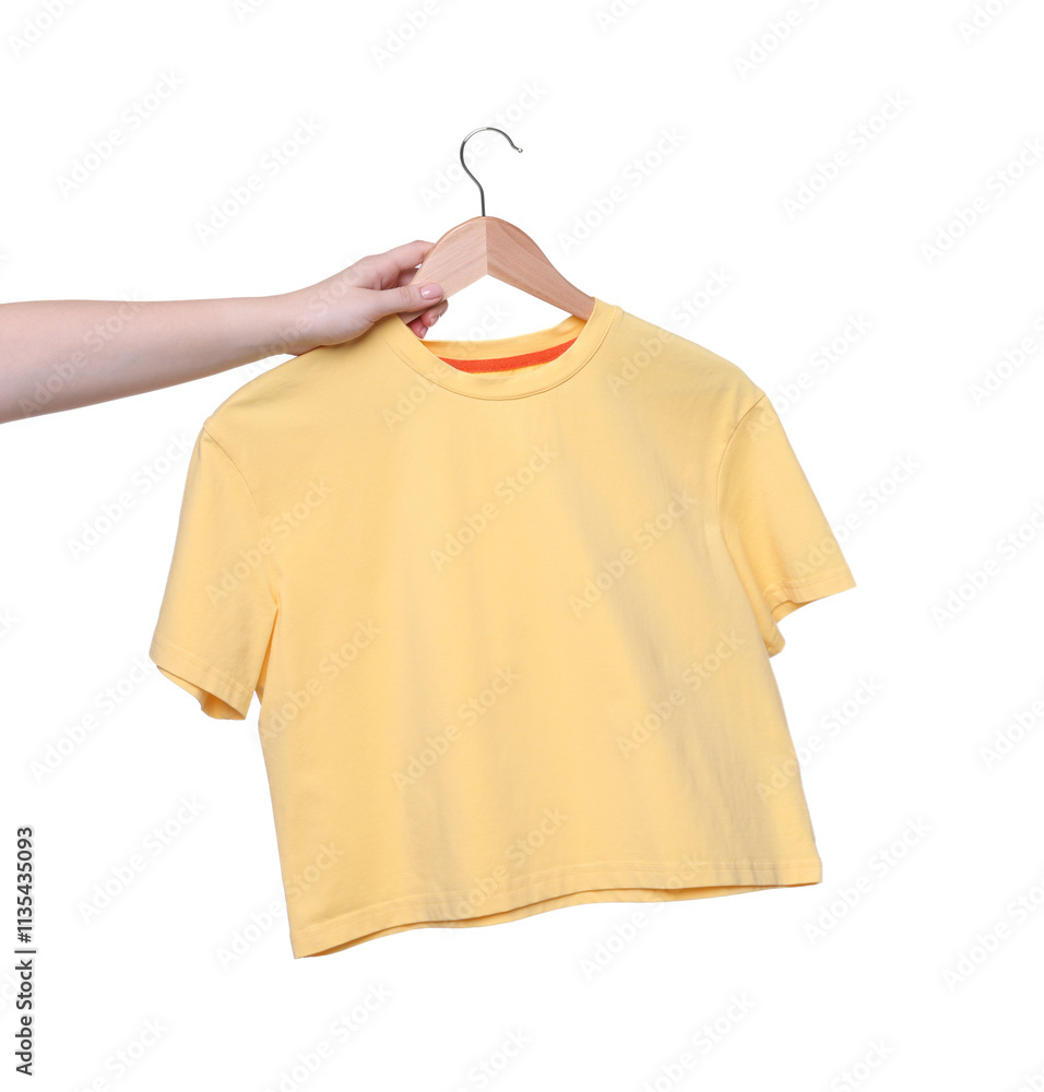 Woman holding hanger with yellow t-shirt on white background, closeup Woman holding hanger with yellow t-shirt on white background, closeup
