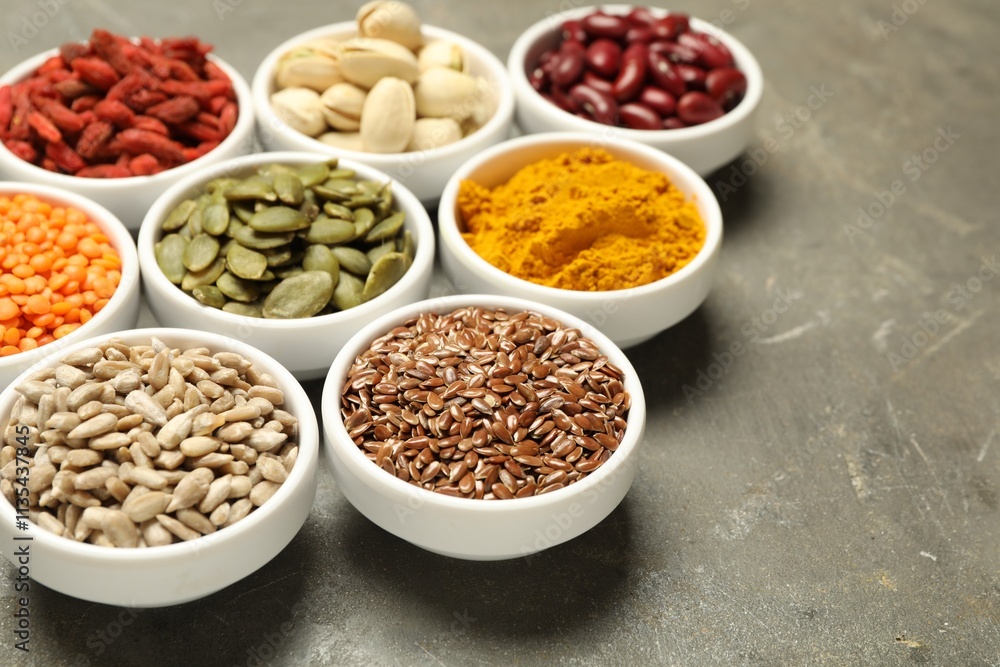 Different superfoods in bowls on grey table, closeup Different superfoods in bowls on grey table, closeup